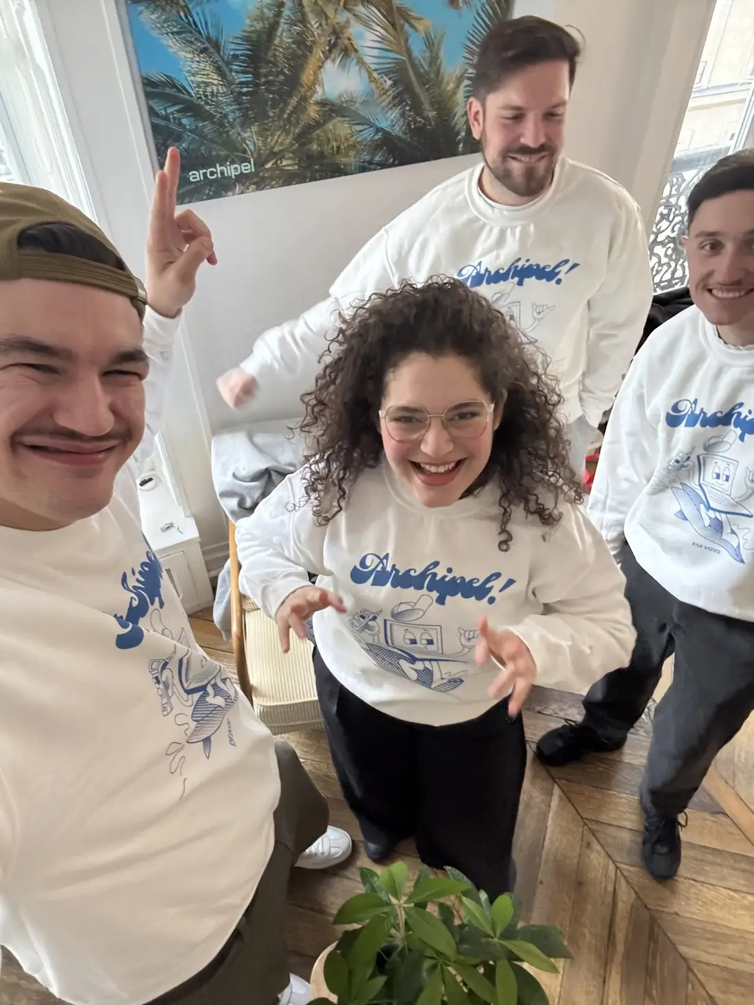 L’équipe Archipel en sweats de l’agence, doigt levé pour la première place